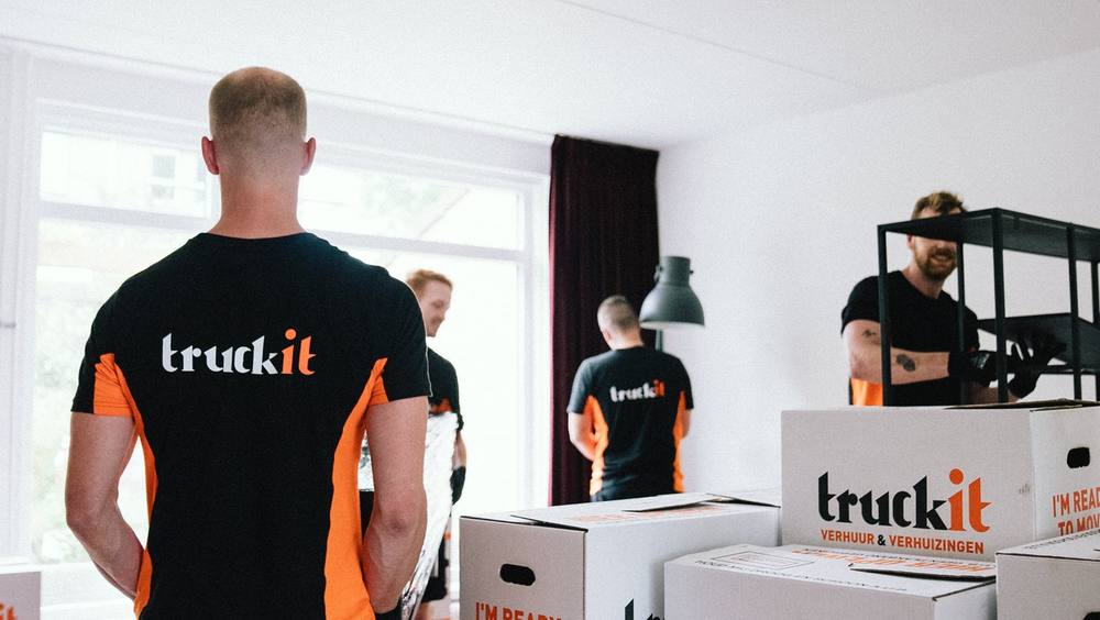 Verhuizers van Truckit met verhuisdozen in een woonkamer