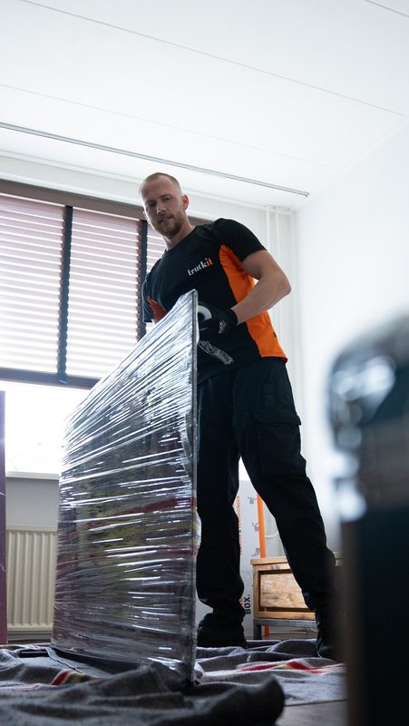Verhuizer van Truckit met een in folie gewikkeld meubel