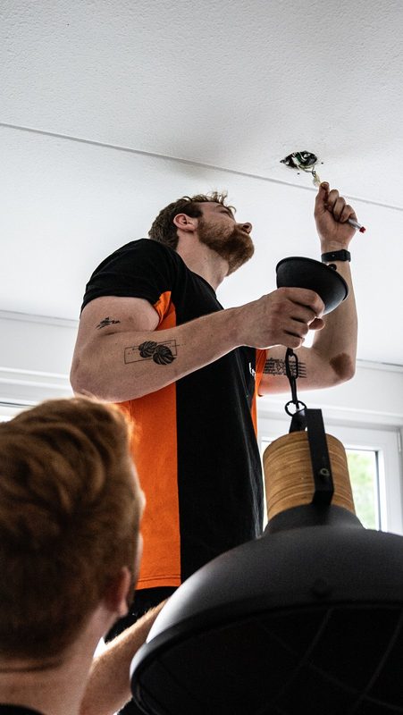 Verhuizer van Truckit hangt een lamp op