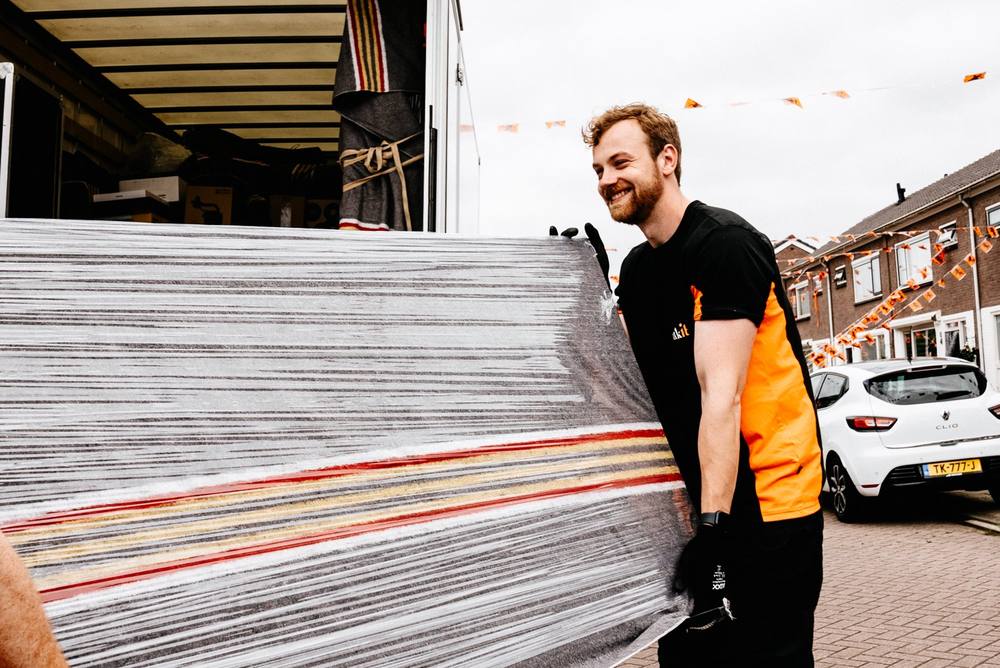 Verhuizer van Truckit draagt een ingepakt matras naar de verhuiswagen