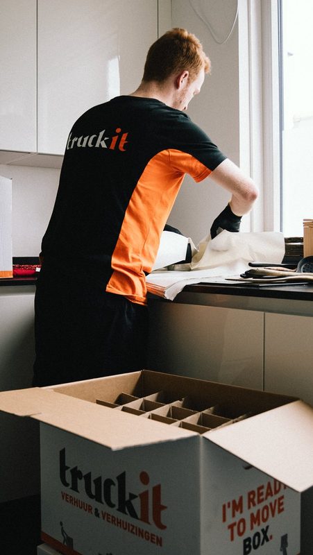 Verhuizer van Truckit pakt servies in een verhuisdoos
