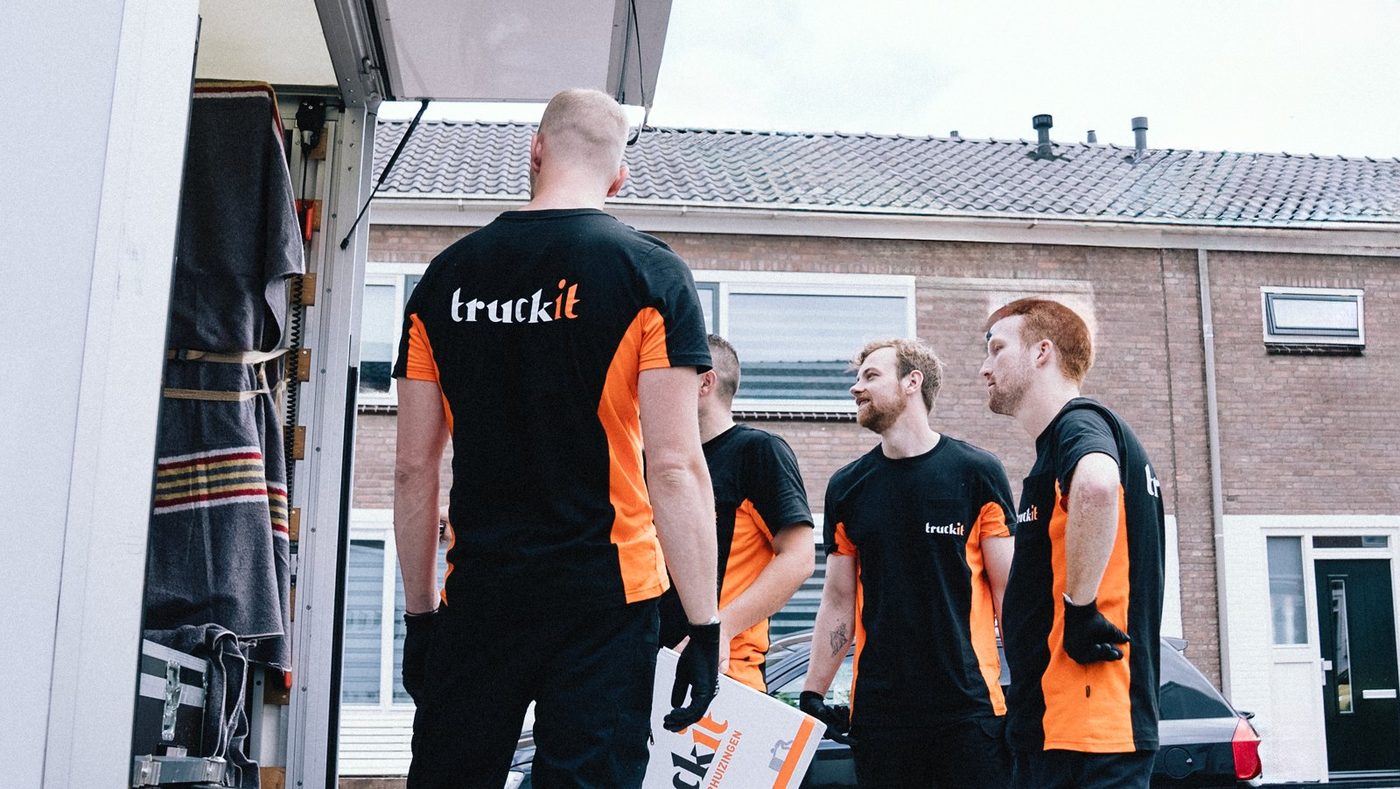 Vier verhuizers van Truckit overleggen bij de verhuiswagen