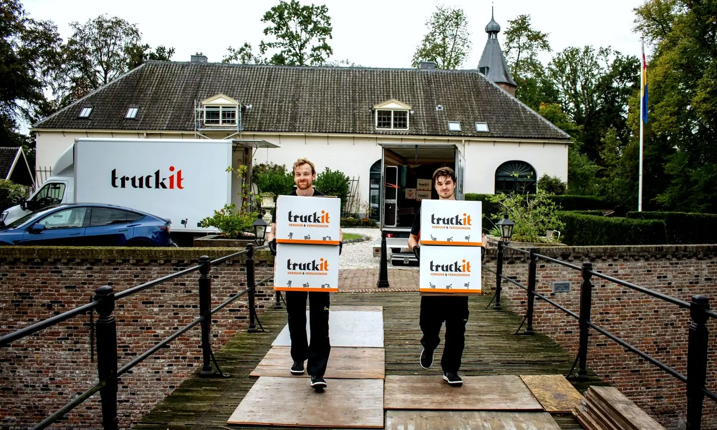 Twee verhuizers van Truckit met verhuisdozen voor de verhuiswagen