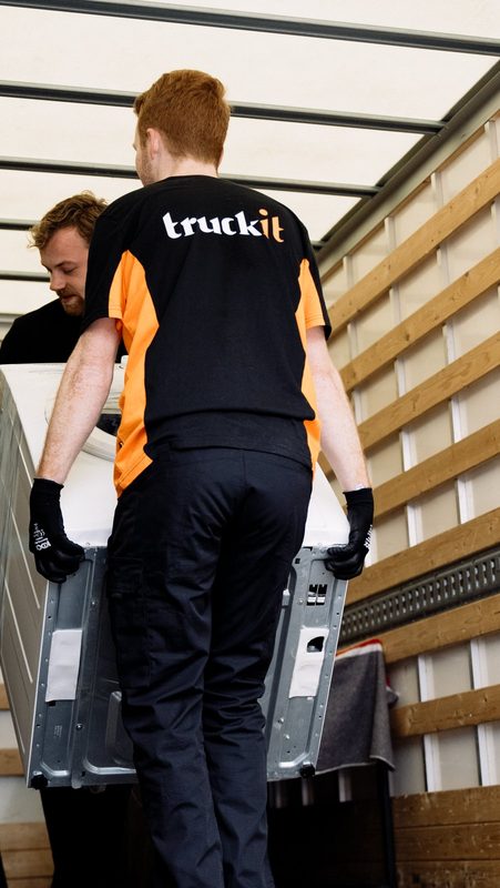 Twee verhuizers van Truckit zetten een wasmachine in de verhuiswagen